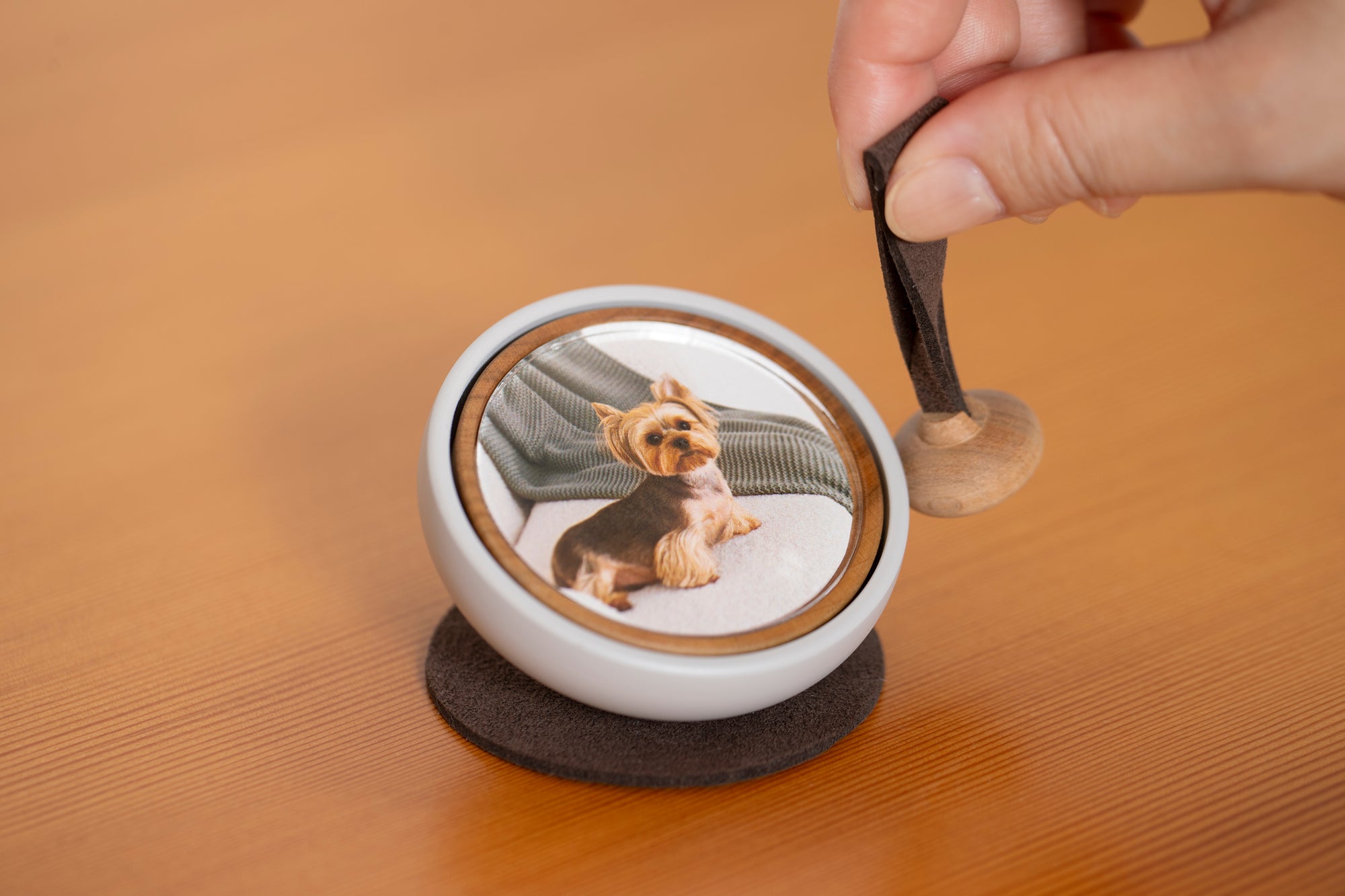 Hand gently ringing the Tailo pet memorial bell with the swaying mallet